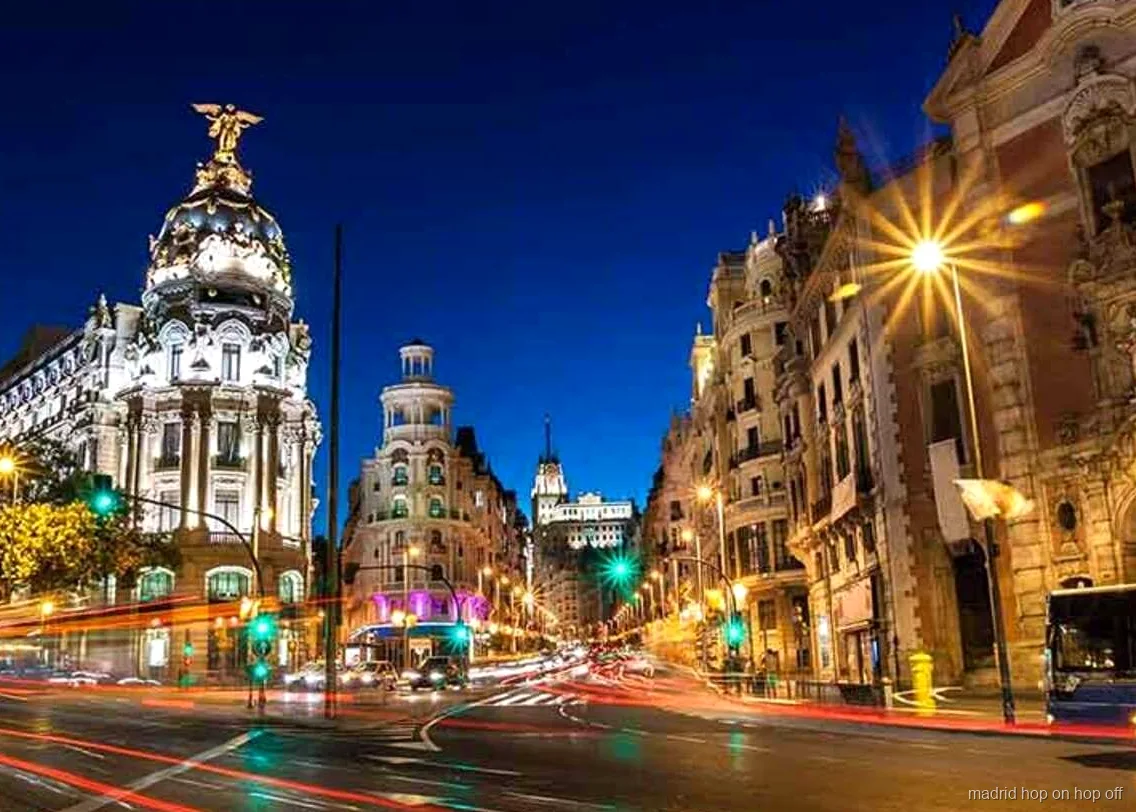 Madrid hop-on hop-off night tour bus passing illuminated landmarks