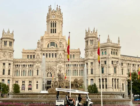 Guia bilingüe conduint un tuk tuk elèctric per Madrid