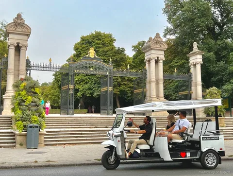 Tuk tuk électrique arrêté près d'un monument de Madrid pour des photos