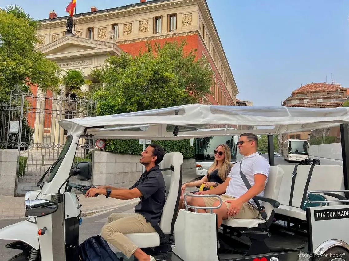 Tour privato in tuk tuk elettrico che passa davanti al Palazzo Reale di Madrid