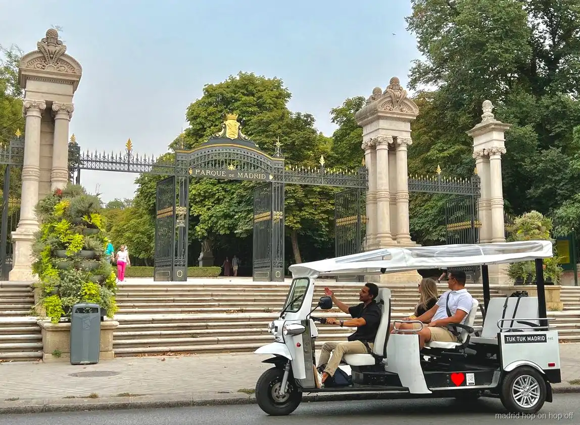 Tuk tuk elétrico parado perto de um marco de Madrid para fotos
